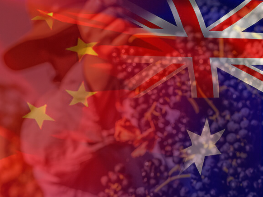 China's and Australia's flags in the foreground. In the background is a man harvesting Australia's number one wine grape, the Australian Shiraz (Photo by: Wine Australia)