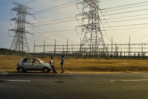 Two men talking by the roadside next to power lines in Sungai Petani, Kedah, Malaysia. | Photo by Ravin Rau on Unsplash