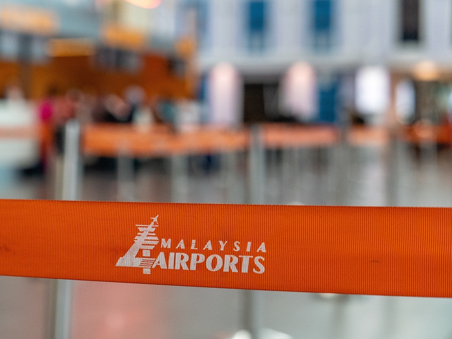 Malaysia Airports Holdings Berhad logo seen on orange queue line barrier at an airport in Malaysia. | Photo by Sangga Rima Roman Selia/Unsplash/NHA File Photo