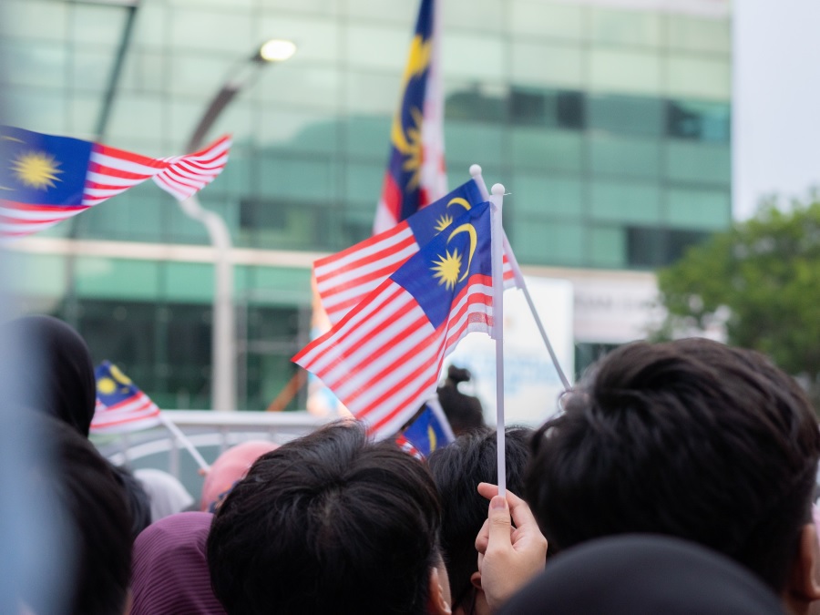 People waving the Malaysian flag. | Photo for illustrative purpose only. | Photo by Putra Mahirudin/Unsplash/NHA File Photo