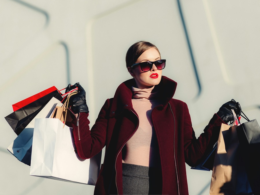 Photo of a woman holding paper bags. Fashion and beauty conceptual photo. Photo by Freestocks / Unsplash / NHA File Photo