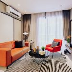 The Type B living room combines elegance and comfort with linen walls, a camel leather sofa, and a geometric carpet.