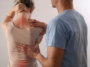 Woman with back pain. Spine physical therapist and patient. Chiropractic pain relief therapy. | Photo by Albina Gavrilovic / Getty Images (via Canva Pro) / NHA File Photo