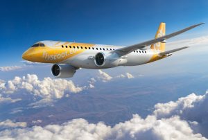 Scoot Embraer E190-E2 jet flying above the clouds that float over a city under a blue sky. | Photo by Scoot / NHA File Photo