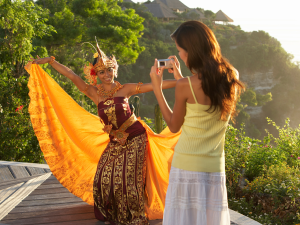 A tourist photographing a traditional dancer in Indonesia. | Photo by Pinnacle Pictures / Photo Images (via Canva Pro) / NHA File Photo