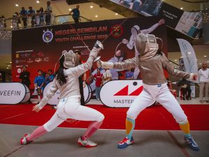 Two sabre fencers engage in a dynamic bout at the Negeri Sembilan Youth Challenge (NSYC) 2025, which was held at Centerpoint Seremban in Negeri Sembilan, Malaysia. 21-23 June 2025. | Photo by Negeri Sembilan Fencing Association / NHA File Photo