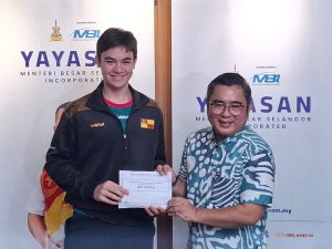 Selangor fencing talent, Saif Nordin, receiving Yayasan MBI's contribution from the foundation chief Ahmad Azri Zainal Nor to support his training and competition expenses. | Bangunan Darul Ehsan, Shah Alam, Selangor, Malaysia. 3 July 2025. | Photo by News Hub Asia