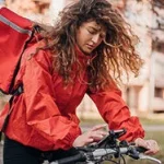 woman-delivery-partner-riding-bike-looking-at-phone