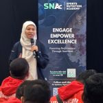 SNAc speaking with a room full of athletes in Malaysia